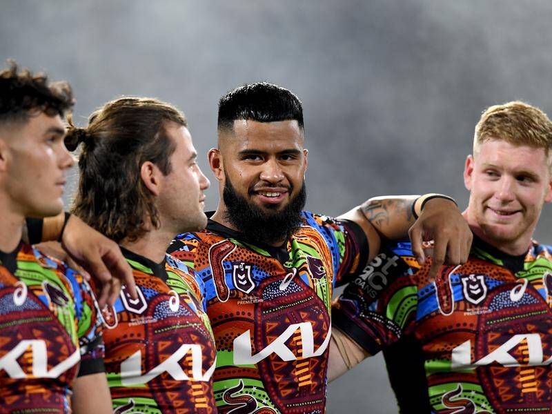 Payne Haas (centre) with his Broncos teammates during the victory against Gold Coast Titans .