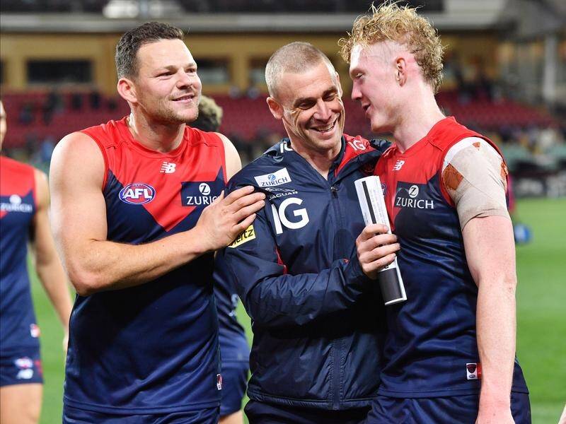 Coach Simon Goodwin (centre) says Melbourne are back in business in the AFL premiership race.