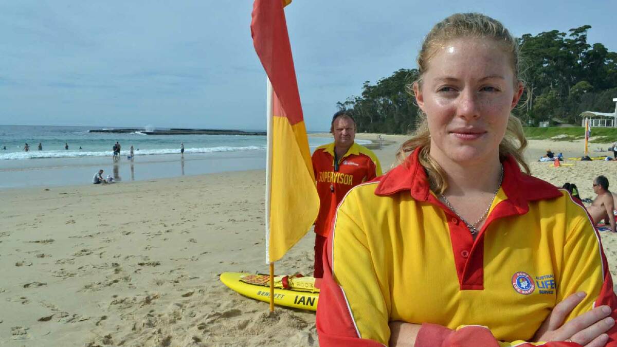 ON DUTY: Lifeguards Ken Walsh and Danielle McKenzie put up the flags on Mollymook Beach yesterday morning to signal the return of lifeguard services. It had a big impact, with hundreds on the beach and more than 60 people in the water at any one time during the day.
