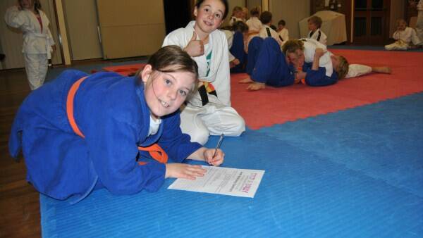 JUDO COMMITMENT: Jessica Lesslie and Eva Gautier sign an anti-bullying contract as part of the Yuukan Judo Club taking a stand against bullying. 