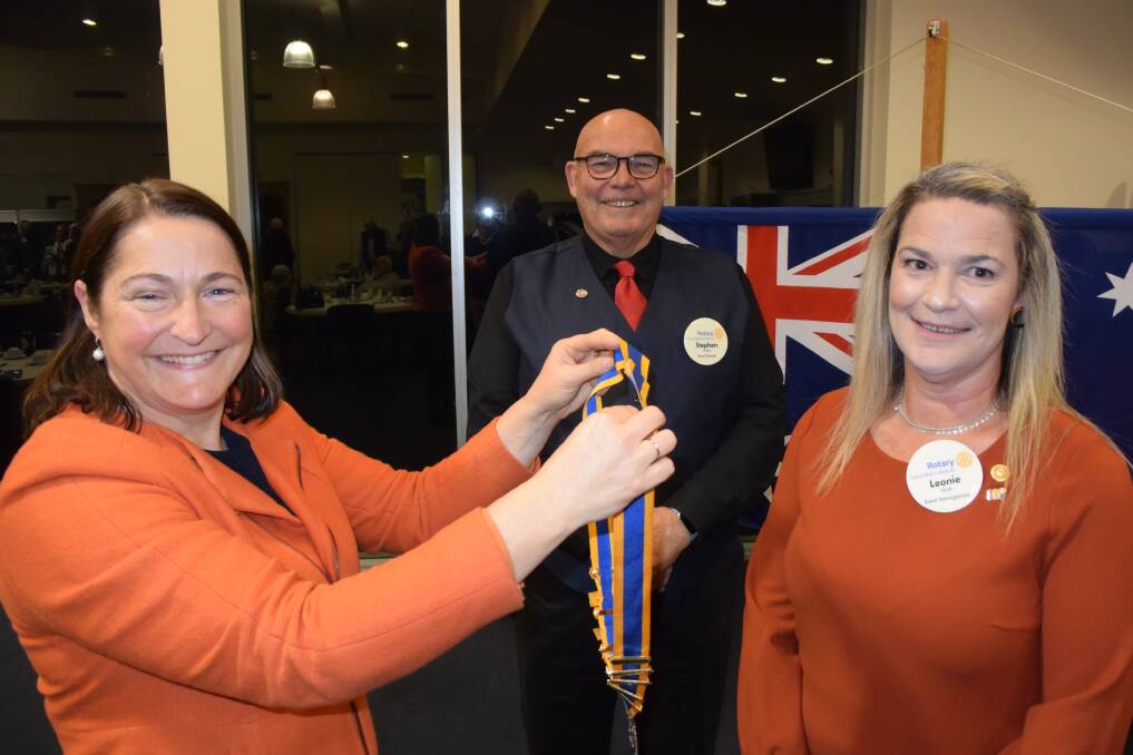 Federal Member for Gilmore Fiona Phillips conducts the changeover role which sees Leonie Smith make local Rotary history as past-president Stephen Hladio watches.