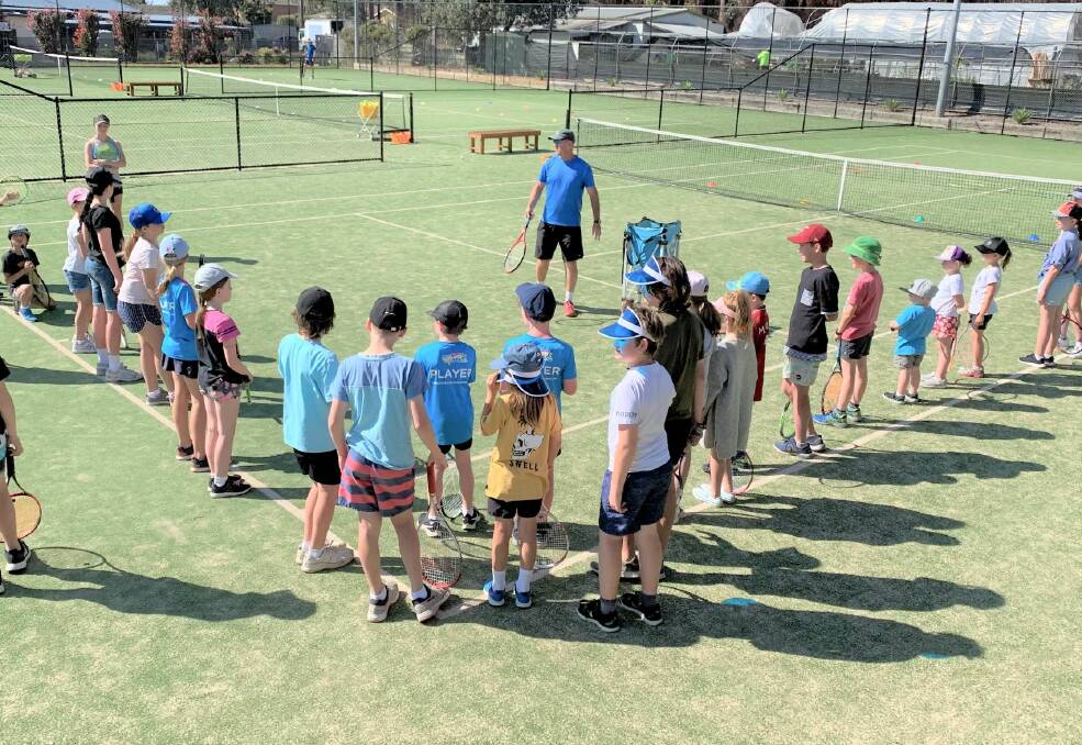Outdoor fun: Kevin Murphy addressing the kids at the start of the school holiday tennis clinic at the Ulladulla courts.