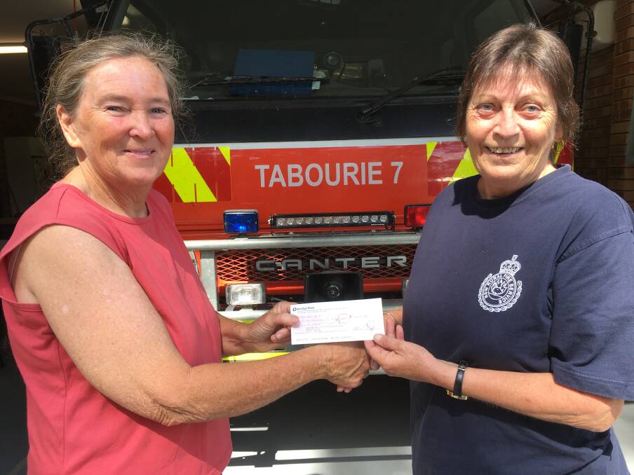 Tabourie Lake Ratepayers and Residents Association Treasurer. Cathy Stapleton hands Tabourie RFB Captain, Di Heggie, a cheque..

