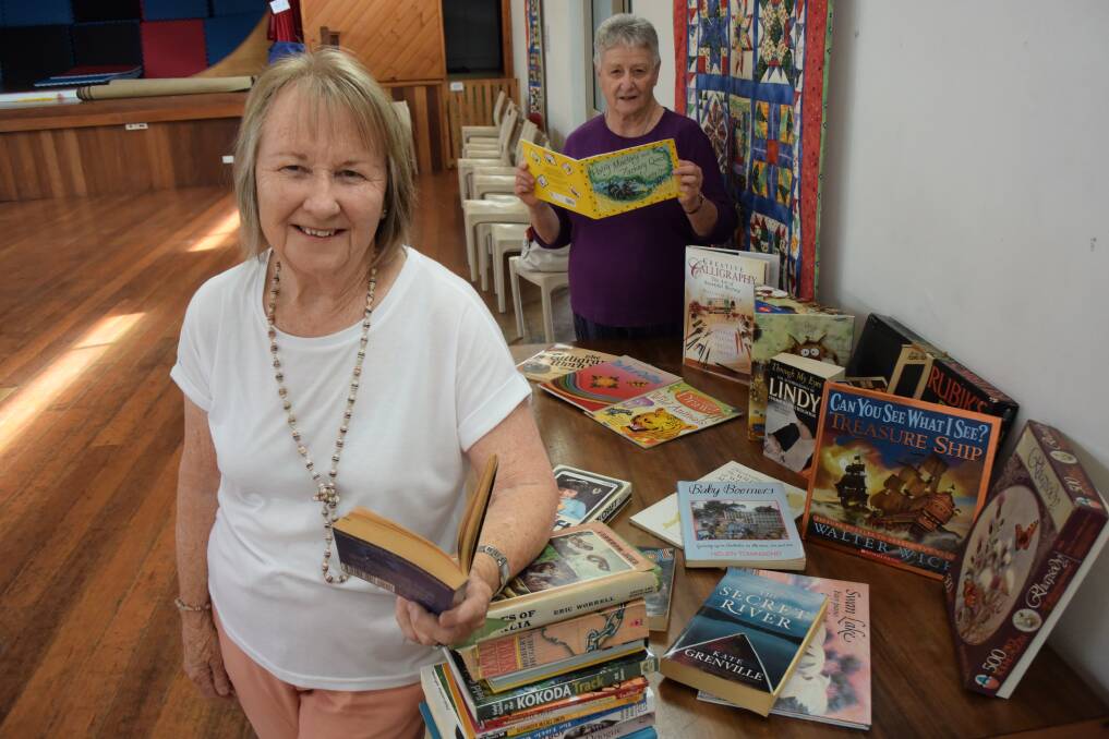 Book sale volunteers Helen Wilford and Glenda Lee get sneak preview.